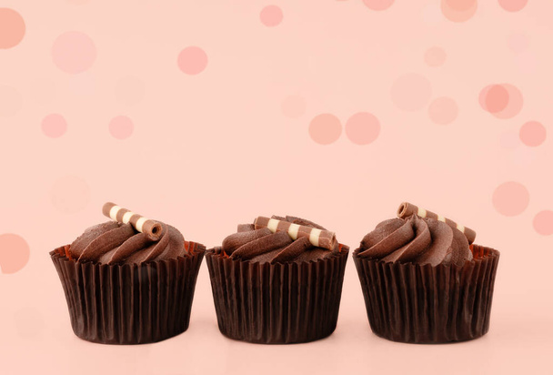 Шоколадные кексы в коричневых обертках на розовом фоне высококачественные фотографии для календаря и открыток. Пространство для текста - Фото, изображение