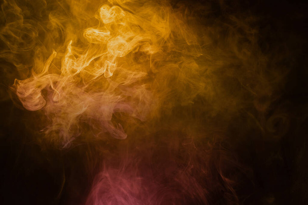 Yellow and pink steam on a black background. Copy space. - Фото, изображение