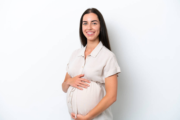 fiatal kaukázusi nő elszigetelt fehér háttér terhes és boldog - Fotó, kép