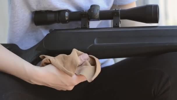 Samice ostřelovače vyčistí optický pohled na svou pušku, zblízka. Dámské ruce otírají prach z pneumatické pušky - Záběry, video