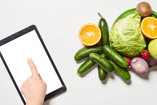 Organic vegetables, fruits and a person using tablet with a blan - Fotografie, Obrázek