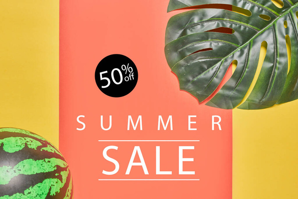 Vente d'été avec des feuilles de palmier et balle sur un backgrou de couleur vive - Photo, image
