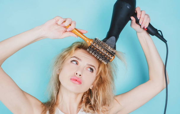 Girl with blonde hair using hairdryer. Hairstyle, hairdressing concept. Health hair and beauty concept - Foto, immagini
