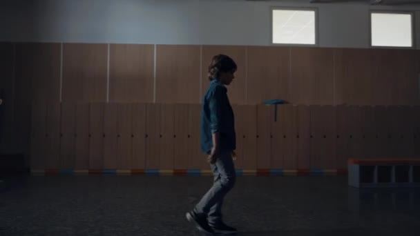 Relaxed pupil walking dark school hall alone. Thoughtful calm elementary age student going downstairs empty corridor after classes. Teen schoolboy passing lockers classrooms. Education concept. - Footage, Video