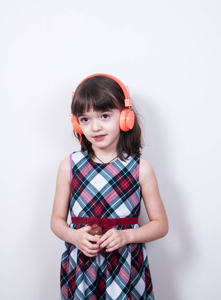 A kislány a fülhallgatót használja. - Fotó, kép