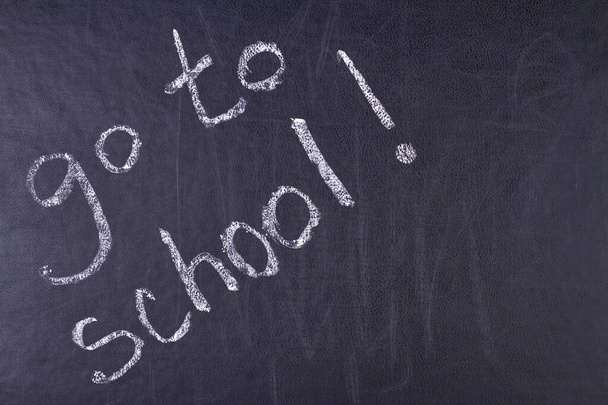 Handwritten inscription go to school on black chalkboard close up. Time for education concept. - Photo, Image