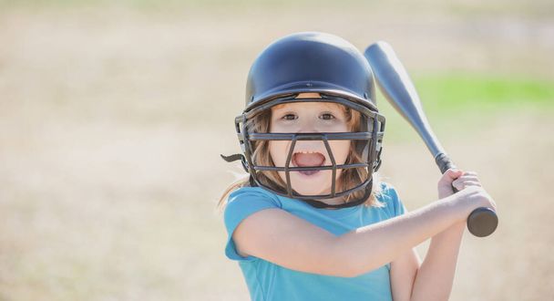 Portrait of excited kid baseball player wearing helmet and hold baseball bat - Fotó, kép