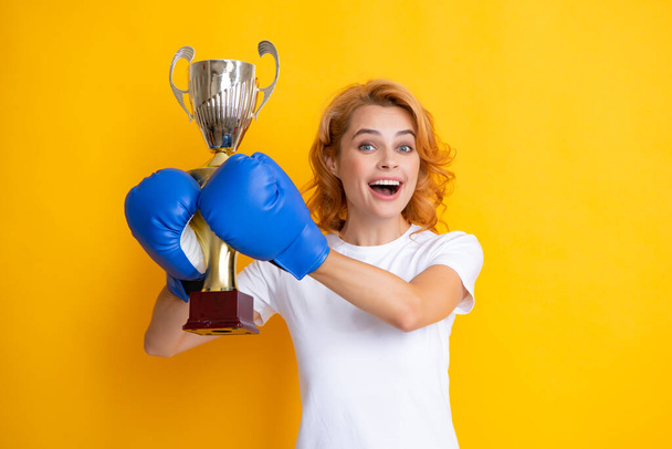 Cheerful woman celebrating victory. Woman in boxing gloves hold champion winner cup - Foto, immagini