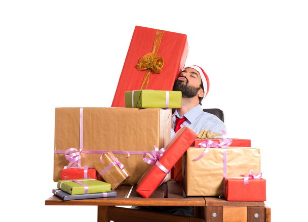 Homme de Noël dans son bureau avec plusieurs cadeaux
 - Photo, image