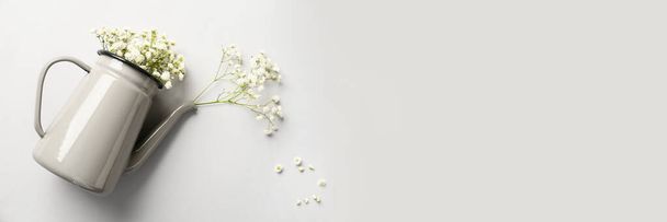Regadera con hermosas flores de gypsophila sobre fondo claro con espacio para texto - Foto, imagen