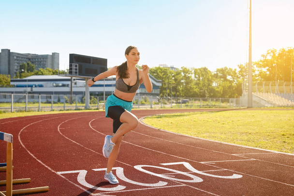 Sporty young woman running at the stadium. Concept of 2022 goals - Foto, Bild