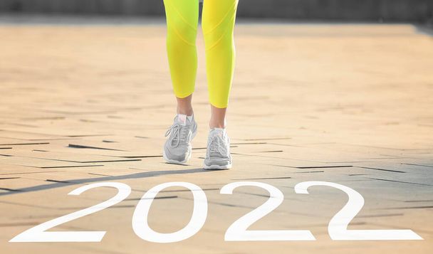 アウトドアを走るスポーティ若い女性。2022年目標の概念 - 写真・画像