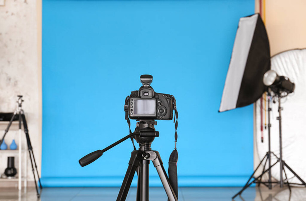 Modern camera with tripod in photo studio - Photo, Image