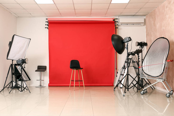 Équipement d'éclairage, chaise et cyclorama dans un studio photo moderne - Photo, image