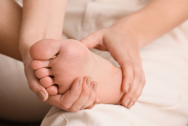 Jovem mulher fazendo massagem nos pés, close-up - Foto, Imagem