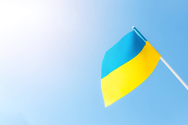 Large bicolor yellow blue Ukrainian state flag, national symbol fluttering, waving in wind against blue sky on sunny day. Kyiv city, capital of Ukraine, Independence Constitution Day, National holiday - Photo, Image