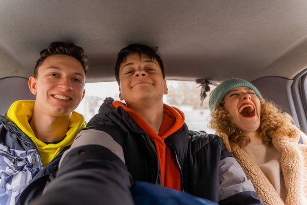 Csodálatos és gyönyörű fiatal baráti társaságok együtt csinálnak egy szelfit az autóban. - Fotó, kép