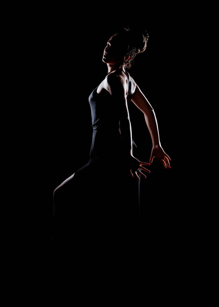 Stylish fashion girl posing  in black fashion clothing isolated on black background - Foto, Imagem