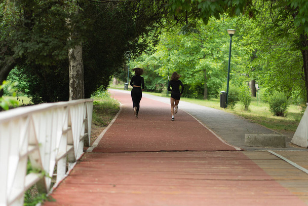 Two girls are running together in the morning on their track - Foto, Imagem