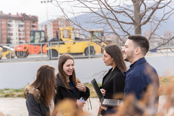 Group of young business people are looking at the construction area while thinking and smiling - Photo, Image