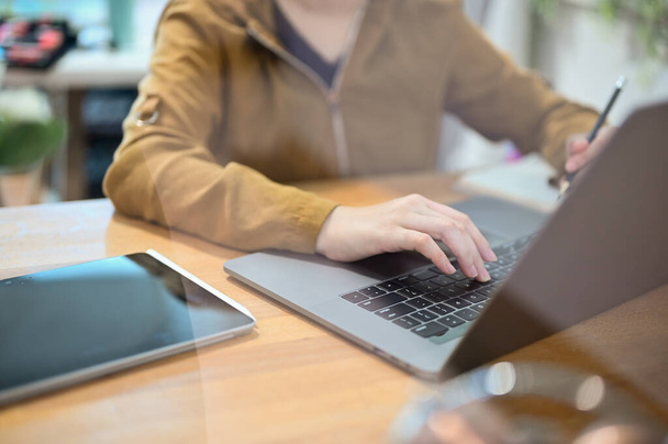 Женщина-офисный работник, использующая ноутбук. Студентка колледжа ищет онлайн-информацию для своих исследований. - Фото, изображение