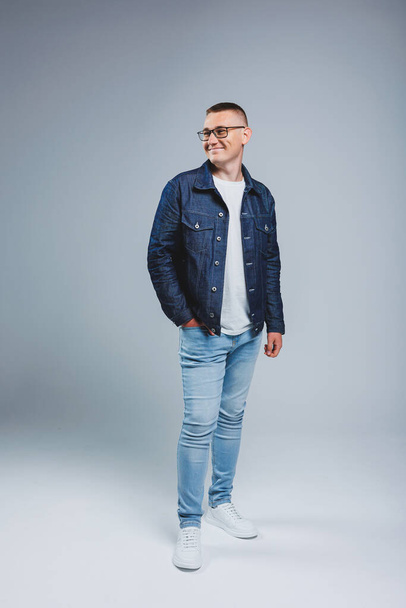 Live a rich life. Positive emotions. Portrait of a young attractive man in a white t-shirt and denim jacket. Men's clothing from the denim collection - Fotografie, Obrázek