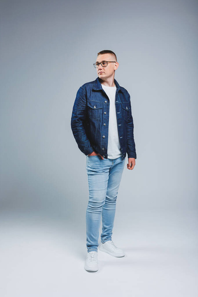 Live a rich life. Positive emotions. Portrait of a young attractive man in a white t-shirt and denim jacket. Men's clothing from the denim collection - Foto, immagini