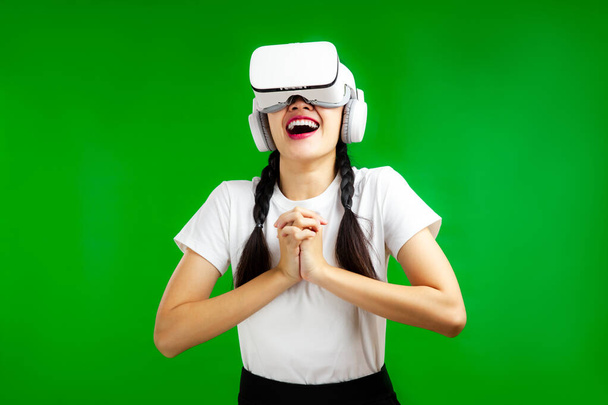 Metaverse Concepts, Asian woman in vr glasses isolated green background, virtual reality headset, People emotions concept. - Foto, imagen