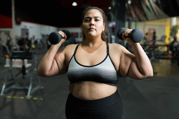 Spaanse jonge vrouw die lijdt aan obesitas gaat naar de sportschool om wat gezond gewicht te verliezen - Foto, afbeelding