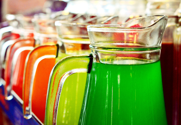 Una fila de jugos coloridos servidos en jarra
 - Foto, imagen