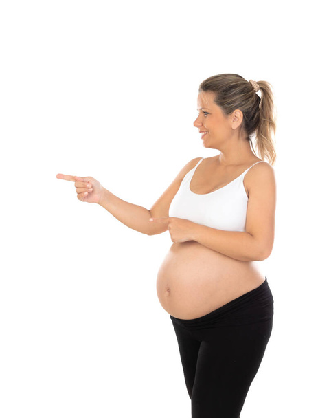 Image of pregnant woman touching her belly with hands isolated on a white background - 写真・画像