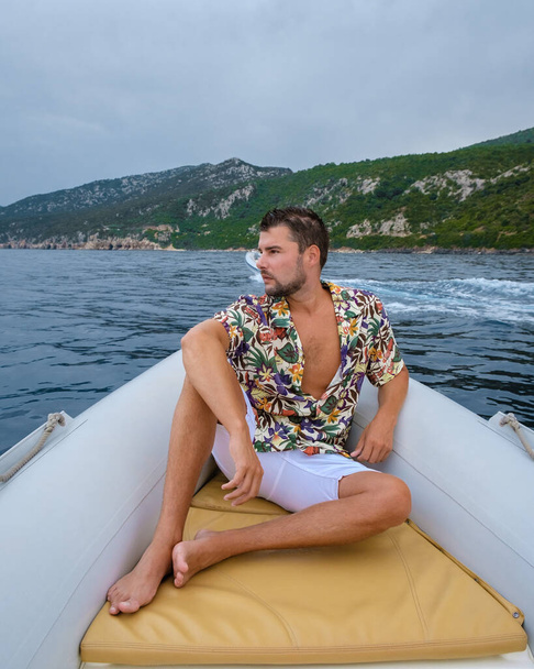 Golfo di Orosei Sardina, Mannen op het strand chillen in speedboot Sardinië Italië, jongeman op vakantie Sardinië Italië, een man die in de oceaan speelt met kristalhelder blauw water - Foto, afbeelding