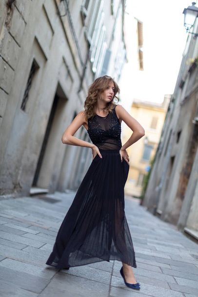 beautiful Italian brunette girl posing in the center of Reggio Emilia in the alleys with long skirt. High quality photo - Foto, Imagem