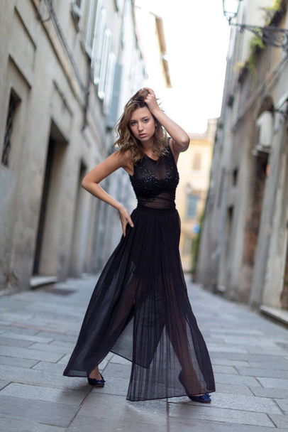 美しいイタリアのブルネットの女の子は長いスカートで路地にレッジョ・エミリアの中心部にポーズ。高品質の写真 - 写真・画像