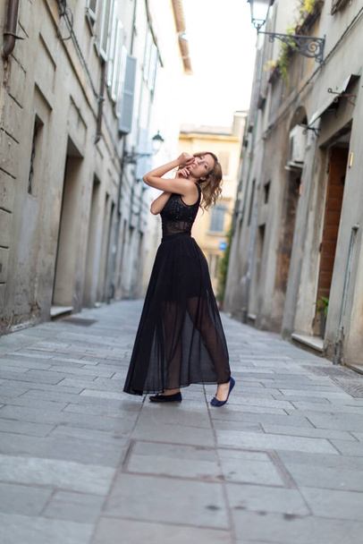 beautiful Italian brunette girl dances in the center of Reggio Emilia in the alleys with long skirt. High quality photo - Foto, afbeelding