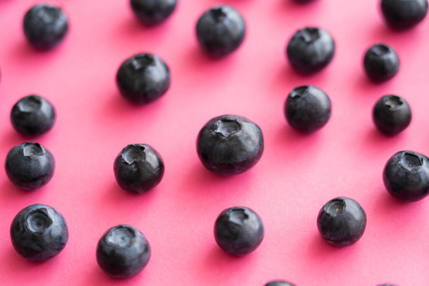 Close up view of fresh blueberries on pink surface - Foto, imagen