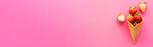 Top näkymä tuoreita mansikoita maukas vohveli kartio vaaleanpunainen tausta, banneri  - Valokuva, kuva