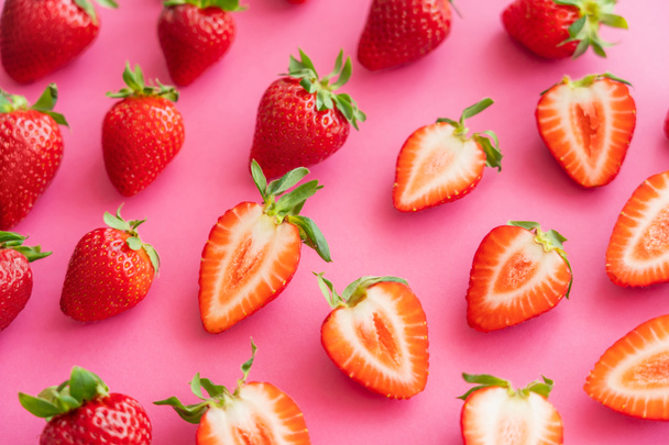 Flat lay with juicy cut and whole strawberries on pink background  - Foto, Bild
