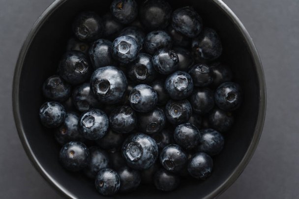 Close up view of organic blueberries in bowl on black background  - Photo, Image