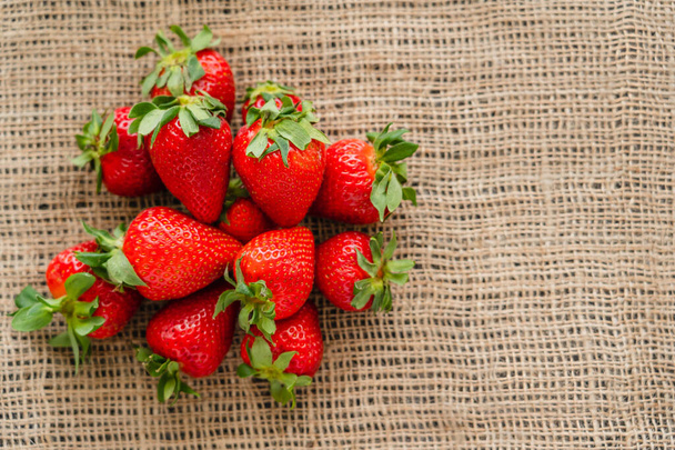 Top view of fresh strawberries on sackcloth - Photo, Image