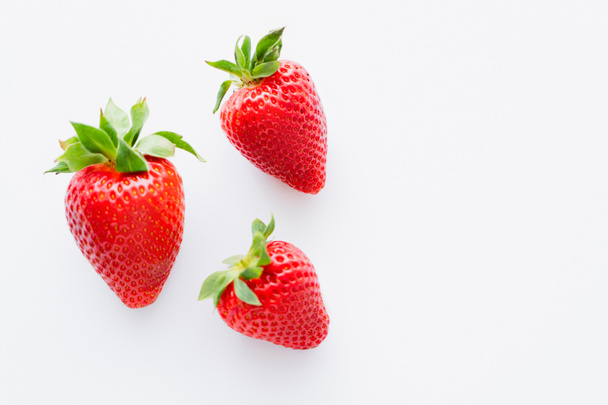Top view of ripe strawberries with leaves on white background  - Foto, afbeelding