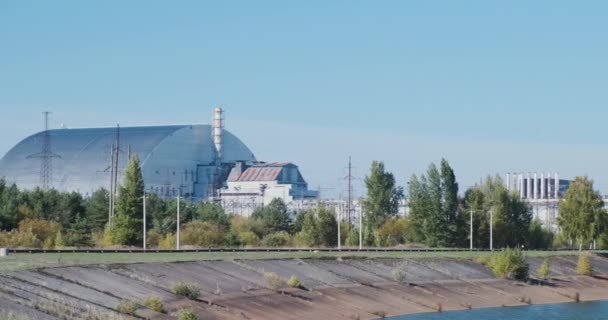 Променевий захист, саркофаг в Чорнобилі, реактор на закритій атомній електростанції, трубах і лініях електропередач. Панорама, вдень, чисте небо. Кадри високої якості 4k - Кадри, відео