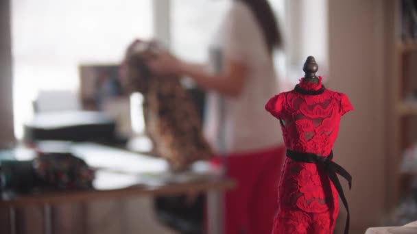 Ein kleines Muster eines Kleides auf einer kleinen Schaufensterpuppe in einem Designstudio - Filmmaterial, Video