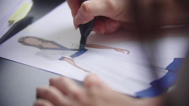 Mujer joven dibujo vestido de diseño utilizando un marcador azul - Imágenes, Vídeo