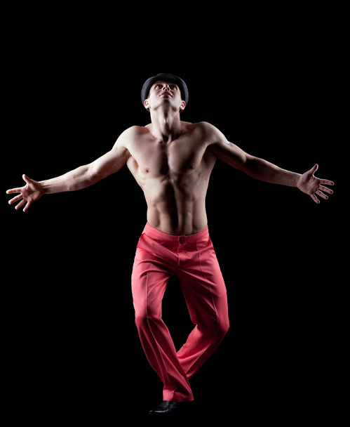 Young naked man dance striptease in red costume - Foto, afbeelding