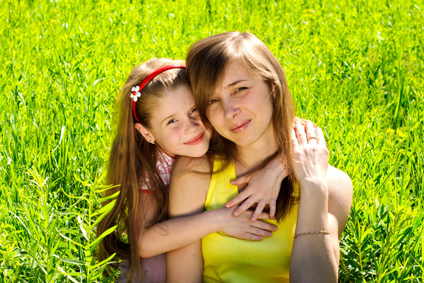 lachende jonge moeder met kleine dochter - Foto, afbeelding