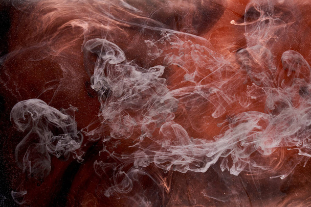 Orange white smoke on black ink background, colorful fog, abstract swirling touch ocean sea, acrylic paint pigment underwater - Photo, Image