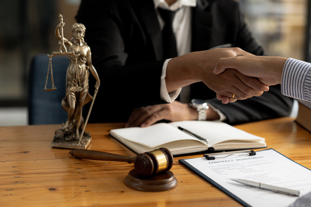 Δικηγόροι δίνουν το χέρι σε πελάτες που έρχονται να καταθέσουν σε περίπτωση υπεξαίρεσης από επιχειρηματικούς εταίρους που επενδύουν από κοινού στην επιχείρηση. Η έννοια της πρόσληψης δικηγόρου για νομικές διαδικασίες. - Φωτογραφία, εικόνα