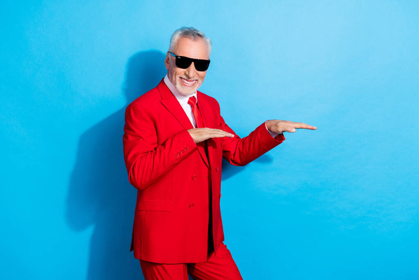 Photo of carefree positive funky pensioner man dance wear sunglass red tux isolated blue color background. - Zdjęcie, obraz