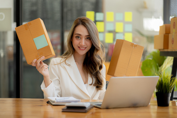 Woman owner of a startup company selling products online on an online store platform, sending goods through a courier company, Business planning. Online selling and online shopping concepts. - Foto, Imagem